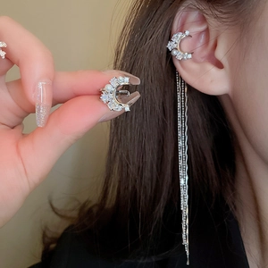 Detail of silver moon ear cuff with dangling tassel chain and shimmering zircon stones