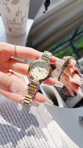 Détail d'une élégante montre bicolore en acier avec cadran en nacre blanche et chiffres romains