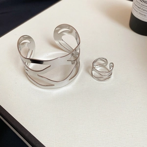 Detailed view of silver irregular wavy cuff bracelet and matching open ring set