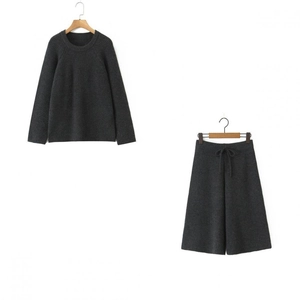 Close-up of dark grey knit texture on round neck sweater and wide-leg trousers set