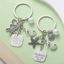 Detailed view of silver sea charms including starfish, seahorse, shell and pearl pendant