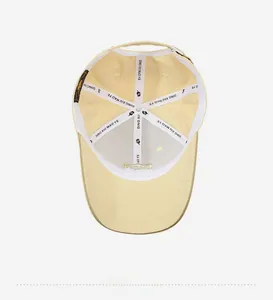 Detail view showing internal reinforced seams and silver metal adjuster of yellow cotton cap