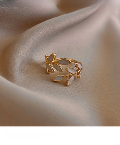 Detailed view of adjustable golden double-leaf ring with white mother-of-pearl inlay