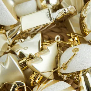 Assorted gold Christmas ornaments featuring stars, bells, and trees with glitter finish
