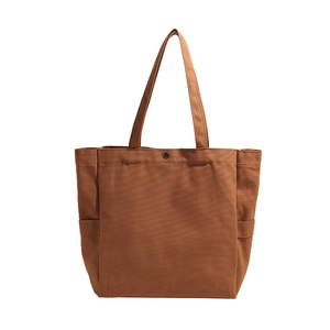 Minimalist canvas tote bag in caramel brown featuring top handles and snap button closure