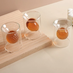 Set of three double-walled creative rugby and golf glass spirit cups on wooden tray