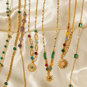 Detailed view of 18K gold plated stainless steel necklaces with turquoise and sun charms