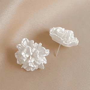 Minimalist white acrylic flower stud earrings with crackle texture on champagne silk