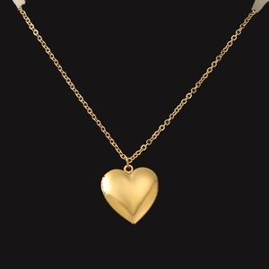 Détail d'un collier médaillon cœur doré avec compartiment ouvrant sur fond noir profond