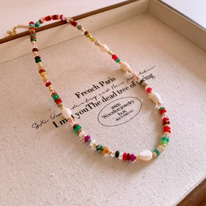 Detail of colorful beads and white baroque pearls on a vintage French style necklace