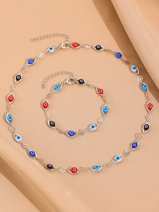 Close-up of colorful evil eye necklace and bracelet set on brown silk background