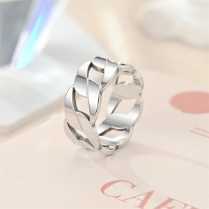 Macro detail of a silver titanium steel ring featuring a stylish hollow chain link design