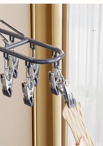Detail of stainless steel drying rack clips with non-slip pads holding yellow fabric