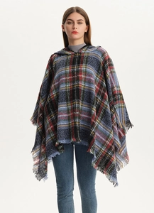 Detail of multi-color plaid hooded poncho with fringe trim and soft knit texture