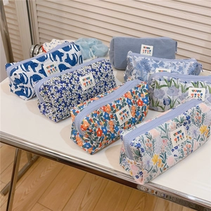 Detail view of assorted floral and corduroy zipper pouches with delicate yuyu labels