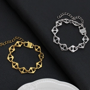Detail shot of geometric diamond link bracelets in gold and silver over black leather