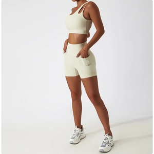 Détail du soutien-gorge de sport asymétrique blanc cassé et du short taille haute