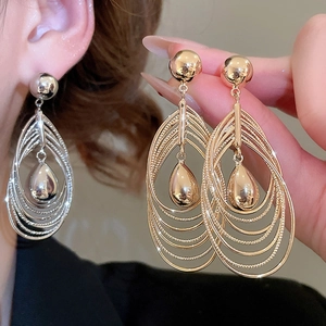 Detail of 18k gold plated multi-layer teardrop earrings with a glossy metal finish