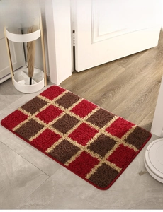 Detailed top view of red and brown checkered plush doormat with thick textured fibers