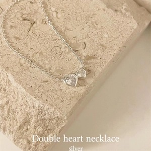 Close-up of S925 sterling silver double heart pendant necklace with zircon stones