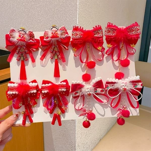Detailed view of red traditional Chinese style hair clips with silk tassels and bows