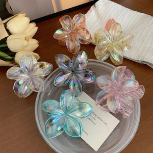 Haarklammer-Set in Blumenform mit irisierendem Aurora-Effekt auf Holzhintergrund