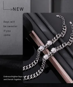 Close-up of silver Cuban chain bracelets with spherical beads and S.STEEL engraving