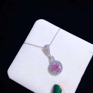Detail of pink crystal pendant necklace with silver chain on a white jewelry pad