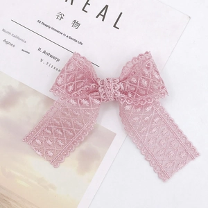 Detailed macro shot of a handmade pink lace bow accessory with intricate mesh texture