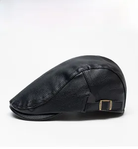 Detail of black leather flat cap showing lychee texture and bronze metal buckle