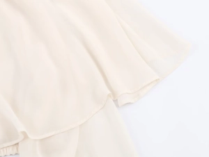 Detail of layered beige georgette fabric showing the elegant drape and fine stitching