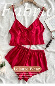 Detail of red satin pajamas set with V-neck camisole and shorts on elegant prop background