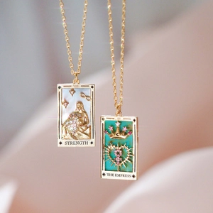 Gold plated tarot necklaces featuring Strength and Empress pendants with crystal accents