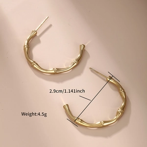 Detailed macro view of 2.9cm gold C-shaped bamboo earrings with size and weight info