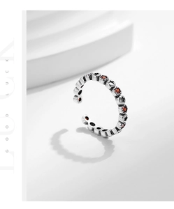 Détail d'une bague en argent avec étoiles, pierres rouges et texte Good Luck