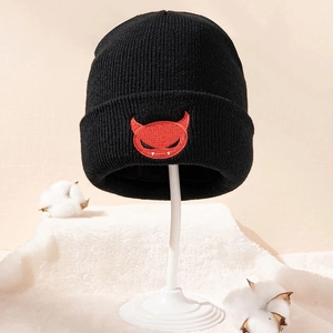 Warm black knitted beanie featuring red devil embroidery on a minimalist white stand