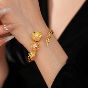 Detail of vintage flower bracelet with gold petals, white pearls, and zircon accents