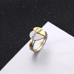 Macro shot of two-tone puzzle heart ring set engraved with BEST FRIEND text