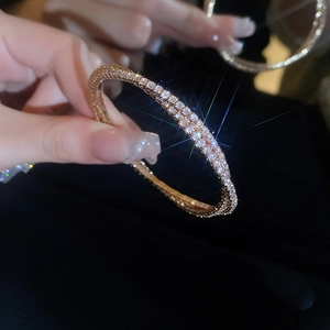 Close-up of rose gold zircon bracelet held in hand with sparkling light effects