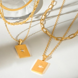 Gold layered stainless steel necklace set with a star engraved rectangular pendant