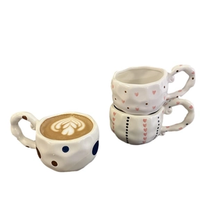 Handmade irregular ceramic coffee mugs with hand-painted heart and polka dot patterns