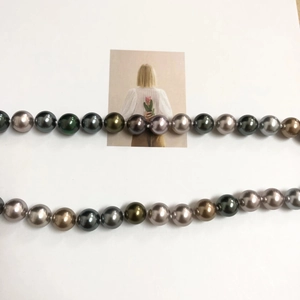 Detailed view of Tahiti peacock green and multicolor pearls with a natural glossy finish
