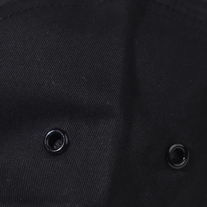 Detail of black twill fabric baseball cap featuring two durable metal ventilation eyelets