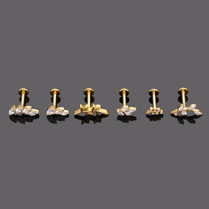Détail de clous de cartilage en titane G23 doré avec motifs feuilles et zircons