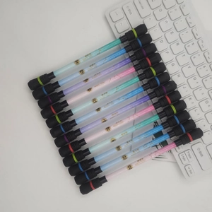 Detail of colorful constellation-themed spinning pens on a white desk with keyboard
