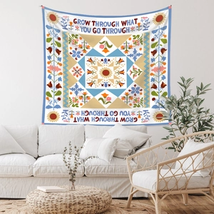 Detail of bohemian tapestry with Grow Through What You Go Through slogan and floral patterns