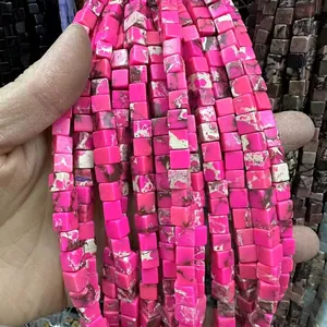 Gros plan de perles cubiques en pierre rose avec textures naturelles pour bijoux DIY