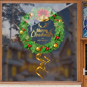 Christmas wreath window sticker with green pine branches, gold bells, and red ribbon bow