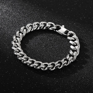 Close-up of industrial silver Cuban link bracelet with a robust folding clasp on black surface