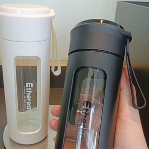 Detail of portable frosted water bottles with carrying strap and clear level window